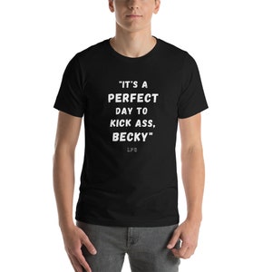 May include: Black t-shirt with white text that reads "IT'S A PERFECT DAY TO KICK ASS, BECKY". The text is centered on the front of the shirt. The shirt is short-sleeved and appears to be made of a soft material.