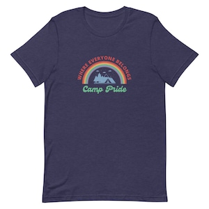 May include: A navy blue t-shirt with a rainbow arc and the text "Where everyone belongs Camp Pride".