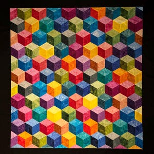 May include: A colorful quilt with a geometric pattern of cubes in shades of blue, green, yellow, orange, red, and purple.