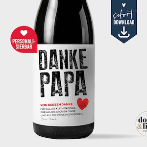 May include: A dark glass bottle with a white label featuring the black text DANKE PAPA, a red heart, and German text that reads VON HERZEN DANKE FÜR ALL DIE KLEINEN DINGE, FÜR ALL DIE GROßEN DINGE UND ALL DIE DINGE DAZWISCHEN. Dein Noah.