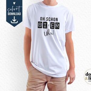 Könnte beinhalten: Ein weißes Kurzarm-T-Shirt mit schwarzem Aufdruck, der OH SCHON lautet, gefolgt von einer digitalen Uhrgrafik mit der Anzeige 8I:ER und dem Wort Uhr! in Schreibschrift unter der digitalen Anzeige auf der Vorderseite des Kleidungsstücks.