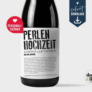 May include: A dark glass wine bottle with a white rectangular label featuring the black text PERLEN HOCHZEIT, SABRINA und THOMAS, and 22.10.2025. A red circular badge says PERSONALISIERBAR, and a blue banner displays the text sofort DOWNLOAD.