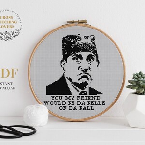 May include: A black and white cross stitch pattern featuring a character from the TV show "The Office" with the text "You my friend, would be da belle of da ball".