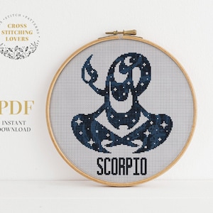 May include: A cross stitch pattern featuring the zodiac sign Scorpio. The design is a stylized scorpion with a starry sky background. The pattern is in a wooden embroidery hoop and the word "Scorpio" is written below the design.