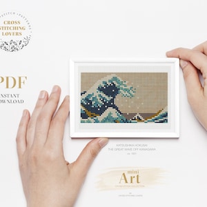 May include: A digital cross stitch pattern of The Great Wave off Kanagawa by Katsushika Hokusai. The pattern is in a white frame and is labeled "mini Art".