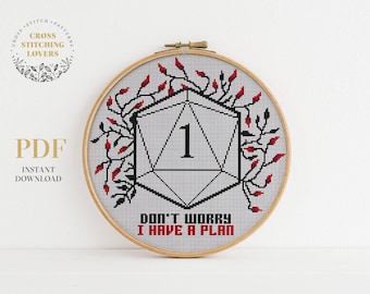 May include: A cross stitch pattern featuring a white and black dice with the number 1 on it. The dice is surrounded by red and black vines. The text "Don't worry I have a plan" is below the dice.