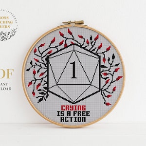 May include: A cross stitch pattern featuring a red and black dice with the number one and the text "Crying is a free action".