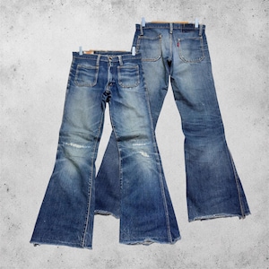 Peut inclure: Deux paires de jeans en denim bleu avec une coupe évasée. La paire avant présente deux poches plaquées carrées sur les hanches et une décoloration légère aux genoux. La paire arrière montre deux poches arrière et une petite étiquette rouge.