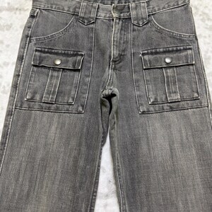 May include: Close-up of gray denim pants with two front pockets and two side pockets. The pants have a button and zipper closure and belt loops. The denim has a faded appearance.