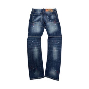 Może przedstawiać: Ciemne dżinsy z efektem rozprysków farby. Jeansy mają klasyczny pięciokieszeniowy design i skórzaną naszywkę z tyłu. Jeansy mają rozmiar 81 cm w talii.