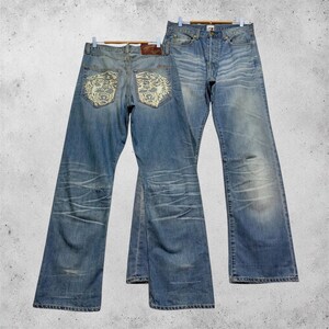 W32 Vintage Ed Hardy by Christian Audigier distressed denim jeans patches met klauwafdrukdesign op de achterzakken, afmetingen 32x32 cm.