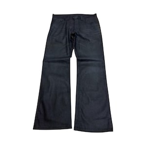 Puede incluir: Vaqueros de mezclilla de lavado oscuro con pernera acampanada. Los vaqueros tienen un diseño clásico de cinco bolsillos, cierre de botón y cremallera, y trabillas para el cinturón. La tela parece ser una mezclilla de peso medio.