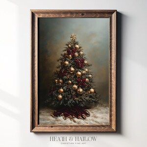 May include: A framed print of a Christmas tree, adorned with gold ornaments, red bows, and a star topper. The tree sits on a bed of white snow, with a dark red fabric at the base. The frame is made of dark wood.
