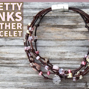 May include: A multi-strand leather bracelet with a silver clasp. The bracelet is adorned with pink, white, and clear beads.