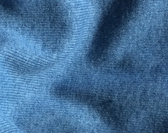 Puede incluir: Primer plano de una tela azul de punto con una superficie texturizada.