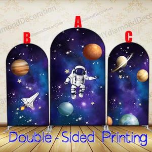 Peut inclure: Un fond de scène à trois panneaux sur le thème de l'espace. Chaque panneau présente un design de galaxie bleu foncé et violet avec des planètes, des étoiles et un astronaute. Le texte "Double-Sided Printing" est en bas.