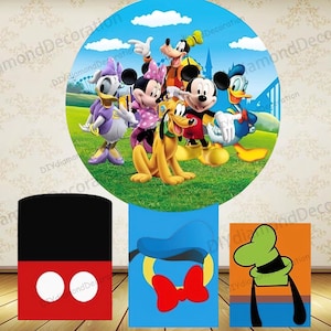 May include: A colorful Disney-themed party decoration set. The main element is a circular backdrop featuring Mickey Mouse, Minnie Mouse, Donald Duck, Daisy Duck, Goofy, and Pluto. Additional cutouts include Mickey's shorts, Donald's hat and bow tie, and Goofy's hat.