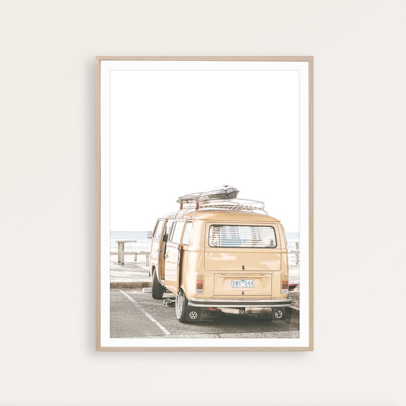 Puede incluir: Una camioneta amarilla vintage con una tabla de surf en el techo estacionada cerca de una playa. La camioneta tiene una placa de matr&iacute;cula que dice "KMV 044".