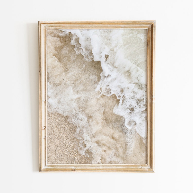 May include: A framed photograph of a beach scene with white foamy waves crashing on the sand.
