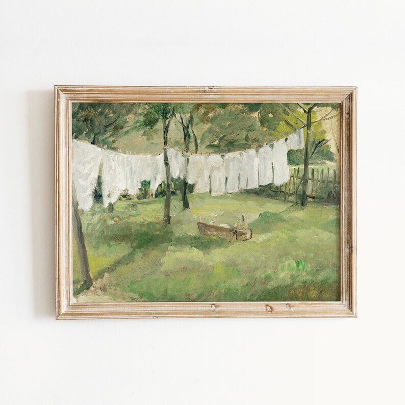May include: A framed painting depicting a rural scene with white laundry hanging on a clothesline between trees. The painting is set against a green grassy field with a small wooden boat in the foreground.
