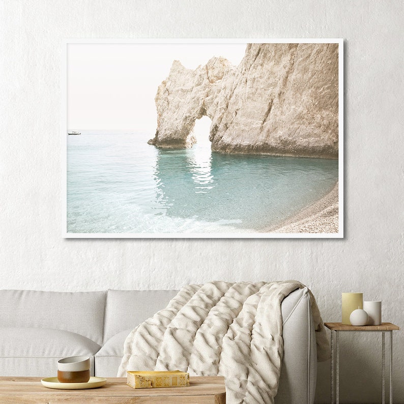 Puede incluir: Una fotograf&iacute;a de un arco de roca natural en una playa con agua azul clara. El arco est&aacute; formado por una gran formaci&oacute;n rocosa con un agujero en el medio. El agua est&aacute; tranquila y clara, y la playa es arenosa.