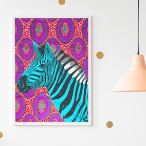 Puede incluir: Una impresión enmarcada de una cebra azul y negra con un fondo estampado rosa y morado. La impresión está colgada en una pared blanca con lunares dorados. Una mesa de alambre blanca con una silla de madera está en primer plano.