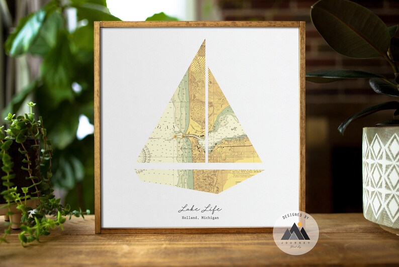 Puede incluir: Una impresi&oacute;n enmarcada con un dise&ntilde;o de velero hecho a partir de un mapa vintage de Holland, Michigan. El texto "Lake Life" y "Holland, Michigan" est&aacute; impreso debajo del velero. La impresi&oacute;n est&aacute; dise&ntilde;ada por "Journey Print Co."