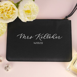 May include: Black zippered pouch with white text that reads "Mrs. Kelleher 14/05/22".