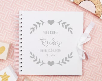 May include: White baby memory book with a gray floral design and the text "Welcome Ruby Born 10.04.2019 7LB 2OZ".