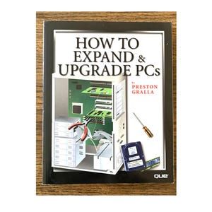 May include: A softcover book titled HOW TO EXPAND & UPGRADE PCs by Preston Gralla. The cover features a graphic of an open computer case, a screwdriver, a hard drive, and a RAM stick. The background is white with a black border and the Que logo.