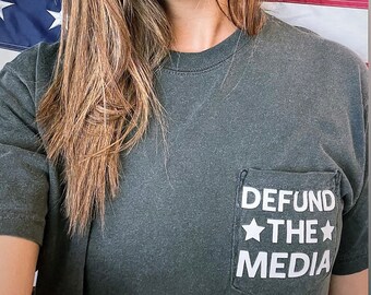 Defund The Media loose fit white washed unisex pocket tee 100% cotton