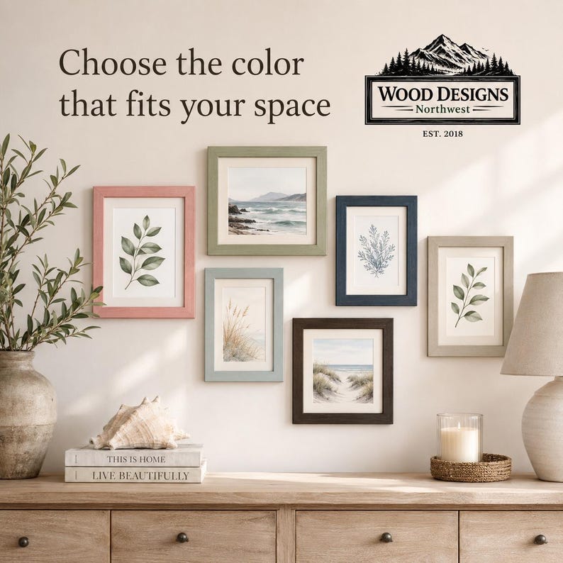 K&ouml;nnte beinhalten: Pr&auml;sentation von gerahmten Kunstdrucken in verschiedenen Farben, darunter Rosa, Gr&uuml;n und Blau, mit botanischen und K&uuml;stenmotiven. Der Text "Choose the color that fits your space" wird &uuml;ber den Rahmen angezeigt. Das Logo von Wood Designs Northwest ist ebenfalls sichtbar.