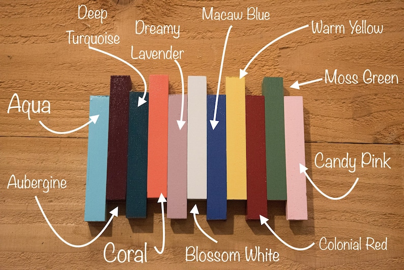 May include: A row of ten paint color samples, each labeled with a name. The colors are: Aqua, Aubergine, Coral, Dreamy Lavender, Blossom White, Macaw Blue, Warm Yellow, Moss Green, Colonial Red, and Candy Pink.