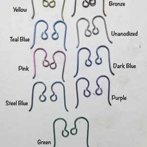 Könnte beinhalten: Sortiment an Ohrhaken in verschiedenen Farben, darunter Gelb, Tealblau, Pink, Stahlblau, Lila, Grün, Bronze, unbeschichtet und Dunkelblau.