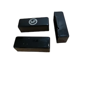 May include: Three black rectangular boxes. One box has a circular logo with the letters "WP" inside.