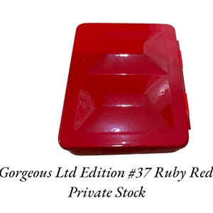 May include: A red metal box with a hinged lid. The box is labeled "Gorgeous Ltd Edition #37 Ruby Red Private Stock".