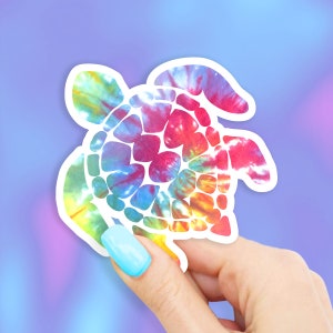 May include: A colorful tie-dye patterned sea turtle sticker. The sticker is white with a rainbow tie-dye pattern.