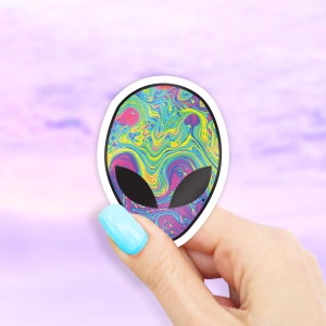 May include: A sticker with a psychedelic alien head design. The alien head is filled with swirling colors of pink, blue, green, and yellow.