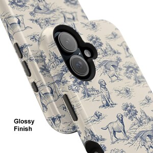 Puede incluir: Funda de tel&eacute;fono brillante con un dise&ntilde;o toile de Jouy azul y blanco con perros, &aacute;rboles, casas y puentes. La funda tiene un acabado brillante y un &aacute;rea negra para la lente de la c&aacute;mara. Las palabras "Glossy Finish" est&aacute;n impresas.