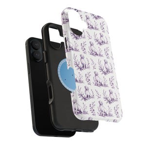 May include: A black smartphone with a protective case featuring a white background and a repeating pattern of purple Labrador Retrievers and floral elements. The case is detached, showing the phone's back.