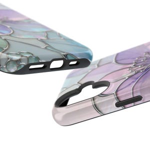 May include: Two phone cases with a floral design. One case is light blue and the other is purple, with a stained glass effect. The cases have black edges and cutouts for the phone's features.