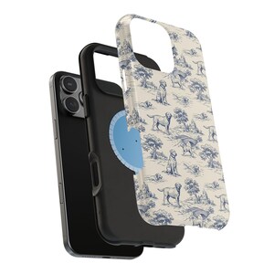 Puede incluir: Un tel&eacute;fono inteligente negro con una funda protectora con un estampado toile de Jouy color crema. El estampado incluye ilustraciones azules de perros, &aacute;rboles y edificios. La funda est&aacute; separada, mostrando la c&aacute;mara del tel&eacute;fono y un accesorio circular azul.