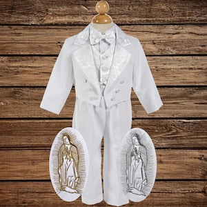 May include: A formal white suit for a young person, including a jacket, vest, pants, and bow tie. The jacket and vest have a textured, patterned trim. Two embroidered oval patches with religious imagery are included.