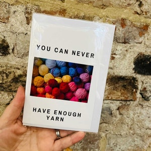 May include: A white card with the text "You can never have enough yarn" and a photo of a variety of colourful yarn balls.