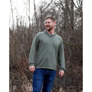 May include: A green long-sleeved sweater with a collared neckline. The sweater is made of a soft, textured fabric.