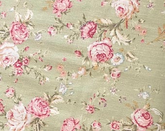 May include: A green fabric with a floral pattern featuring pink roses and green leaves.