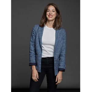 May include: A woman wearing a blue blazer with a white t-shirt and black jeans.