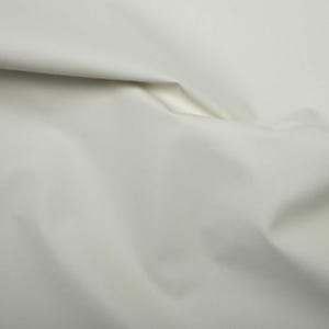 Puede incluir: Un primer plano de una tela blanca lisa con pliegues y arrugas suaves.