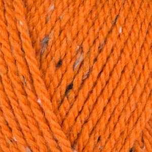Può includere: Primo piano di filato arancione con macchie bianche e grigio scuro. Il filato è spesso e ritorto, con fibre visibili. La trama suggerisce un materiale morbido e caldo, adatto per progetti di maglieria o uncinetto. Il colore è un arancione vibrante e uniforme.