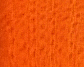Op de afbeelding: Close-up van een feloranje stof met een geweven textuur. Het materiaal heeft een consistente kleur en een licht ruw oppervlak, wat wijst op linnen of een vergelijkbaar textiel. De afbeelding benadrukt de kleur en textuur van de stof.